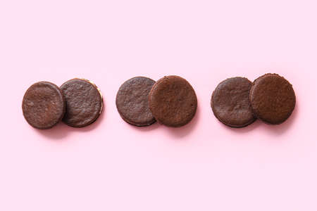 Tasty chocolate cookies with cream on pink backgroundの写真素材