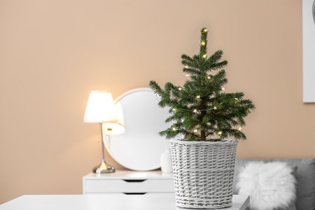 Beautiful Christmas tree in pot on table indoorsの写真素材