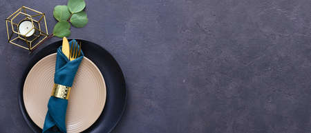 Beautiful table setting with candle on dark gray background with space for textの写真素材