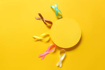 Composition with blank card and awareness ribbons on yellow background. World Cancer Dayの写真素材