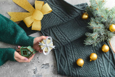 Woman with Christmas decor and knitted scarf on grunge background, closeup