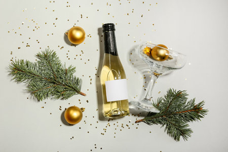 Composition with bottle of champagne and Christmas decor on light backgroundの写真素材