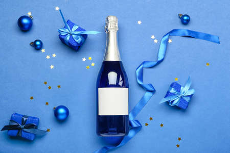 Composition with bottle of champagne and Christmas decor on blue backgroundの写真素材