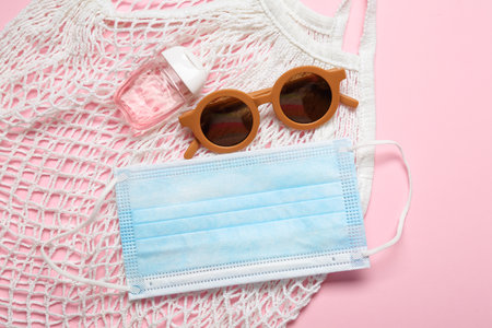Medical mask, sunglasses, bottle with antiseptic and string bag on color backgroundの写真素材