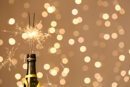 Bottle of champagne with Christmas sparklers against blurred background, closeupの写真素材
