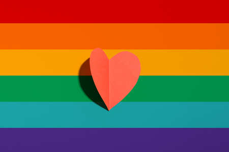 Red paper heart on rainbow background. LGBT conceptの写真素材