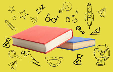 Books and different drawings on yellow background. concept of educationの写真素材