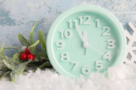 Stylish New Year clock, Christmas decor and snow on blue backgroundの写真素材