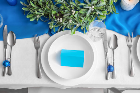 Dining table with setting for Christmas celebration and blank card, top viewの写真素材