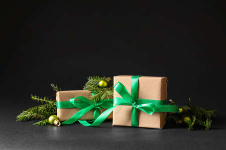 Beautiful Christmas gift boxes, fir branches and balls on black backgroundの写真素材