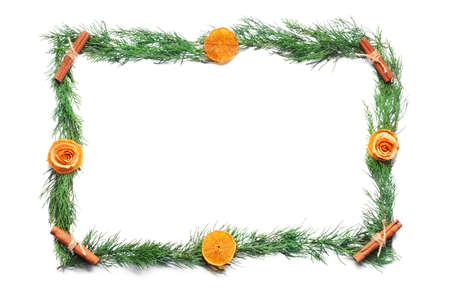 Frame made of coniferous branches, dried orange slices and cinnamon on white background