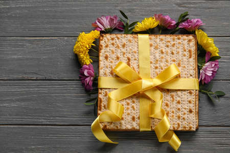 Jewish flatbread with flowers on wooden background