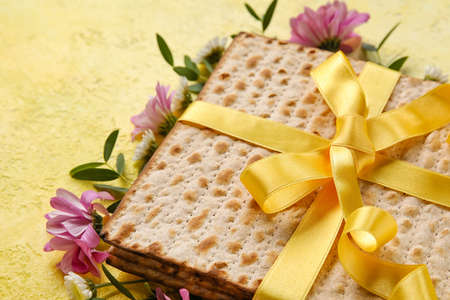 Jewish flatbread with flowers on color background, closeup