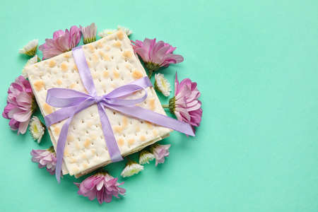 Jewish flatbread with flowers on color background