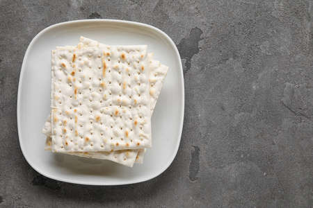 Plate with Jewish flatbread for Passover on grunge backgroundの写真素材