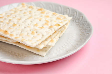 Plate with Jewish flatbread for Passover on color background, closeup
