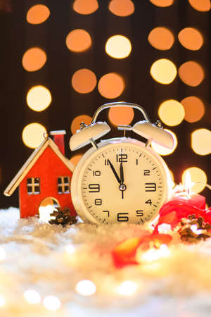 Stylish Christmas clock, decor and snow on table against blurred backgroundの写真素材