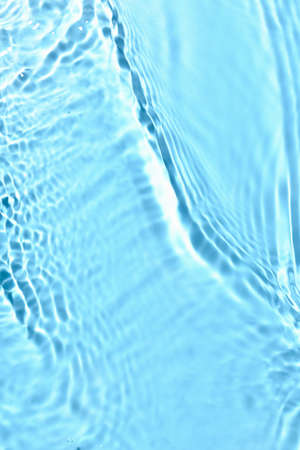 Texture of water with ripples on blue background, closeup