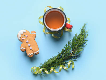 Christmas composition with cookie and cup of tea on color background