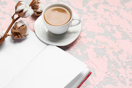 Cup of tasty coffee, book and cotton flowers on light backgroundの写真素材