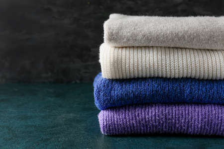 Stack of soft modern sweaters on dark backgroundの写真素材