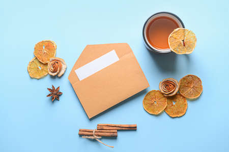 Envelope with spices and cup of tea on color backgroundの写真素材