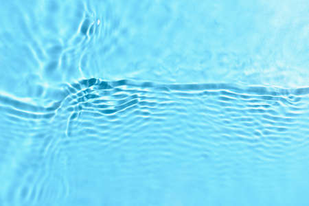 Texture of water with ripples on blue background, closeup