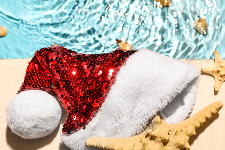 Santa hat and starfishes near swimming poolの写真素材