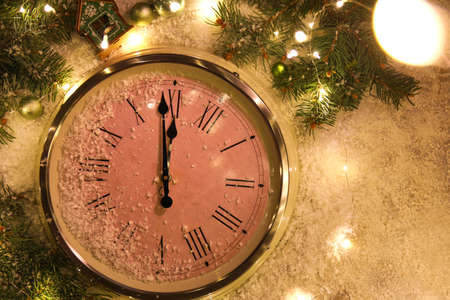 Stylish Christmas clock, decor and snow on table