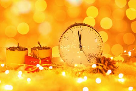 Stylish Christmas clock, decor and snow on table against blurred backgroundの写真素材