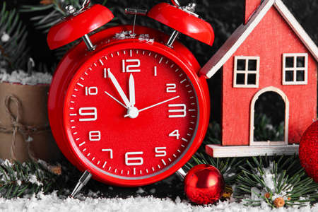 Red alarm clock and Christmas decorations, closeup