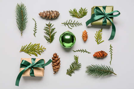 Composition with coniferous branches, cones, gifts and Christmas ball on white backgroundの写真素材