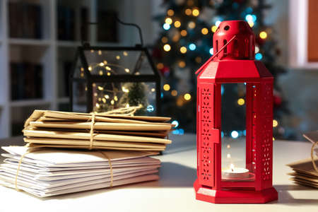 Lantern and letters on table in room decorated for Christmasの写真素材