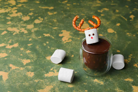 Glass of natural hot chocolate with marshmallows on green backgroundの写真素材