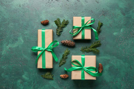 Christmas gifts, cones and fir branches on color backgroundの写真素材
