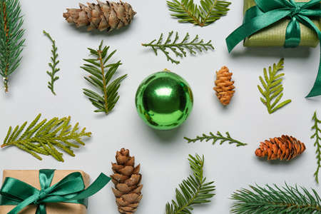 Composition with coniferous branches, cones, gifts and Christmas ball on white background, closeupの写真素材