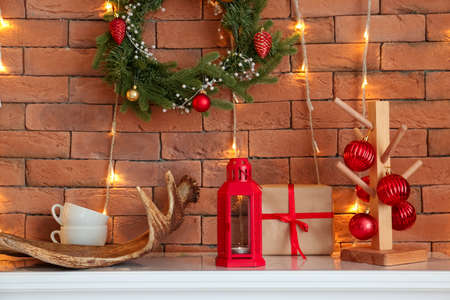 Lantern, gift and Christmas decor near brick wallの写真素材