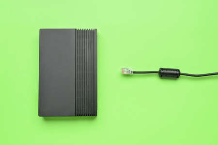 Wifi router and internet cable on green background