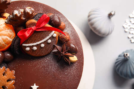 Stand with tasty Christmas chocolate cake and decor on light background, closeupの写真素材
