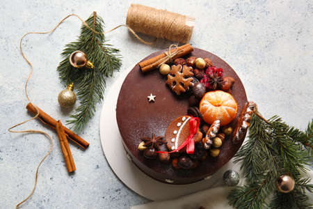 Composition with tasty Christmas chocolate cake and fir branches on light backgroundの写真素材