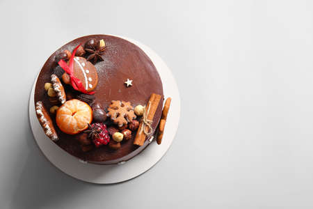 Stand with tasty Christmas chocolate cake on light backgroundの写真素材