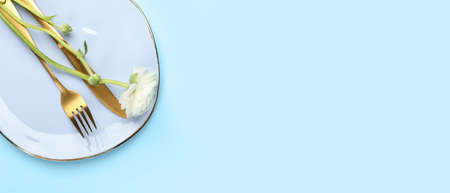 Simple table setting with flower on light blue background with space for textの写真素材