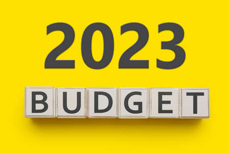 Word BUDGET made of cubes and figure 2023 on yellow background