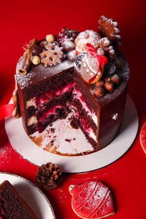 Stand with tasty Christmas chocolate cake on red backgroundの写真素材