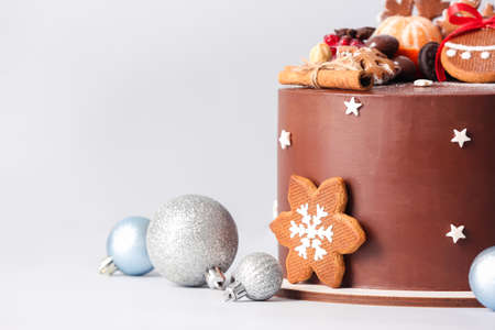 Stand with tasty Christmas chocolate cake and balls on light background, closeupの写真素材