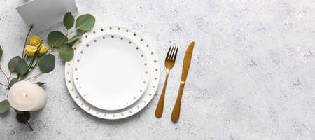 Beautiful table setting with floral decor on light background with space for text