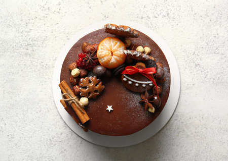 Stand with tasty Christmas chocolate cake on light backgroundの写真素材