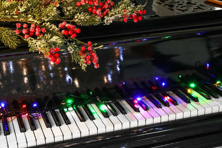 Piano with Christmas balls, glowing lights and rowan berries, closeupの写真素材