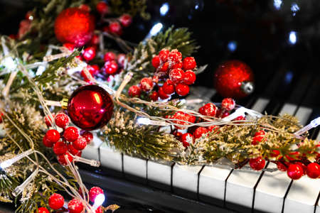 Rowan berries with Christmas ball and glowing lights on piano, closeupの写真素材