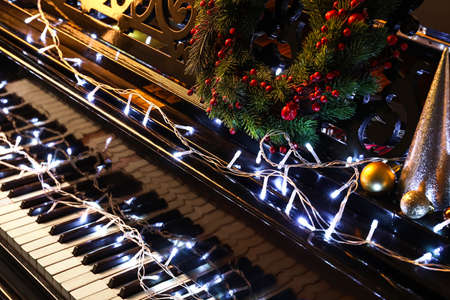 Piano with glowing lights and Christmas decor, closeupの写真素材